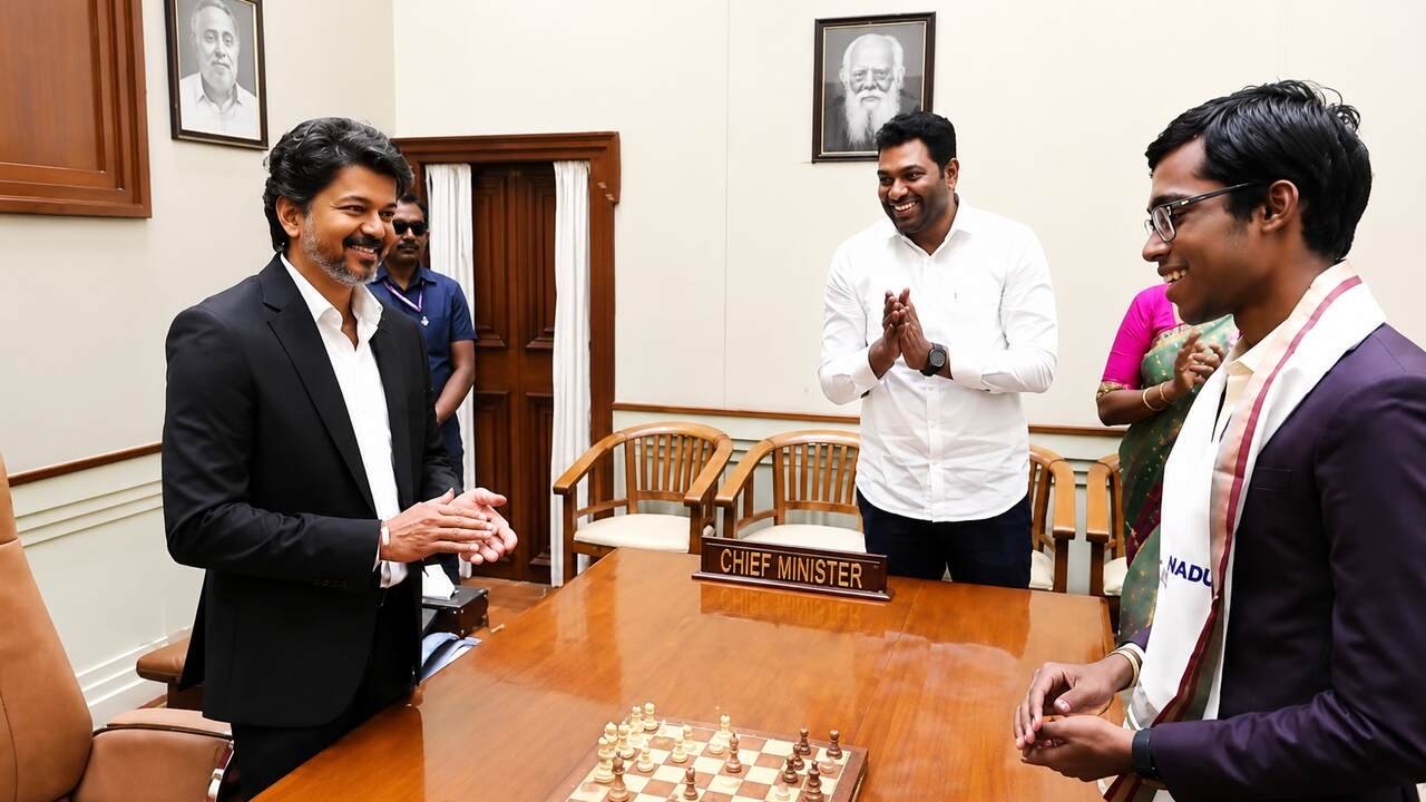 Chief Minister Vijay and Grandmaster Praggnanandhaa interact over a chessboard during a felicitation ceremony celebrating the young champion's Norway Chess title success.